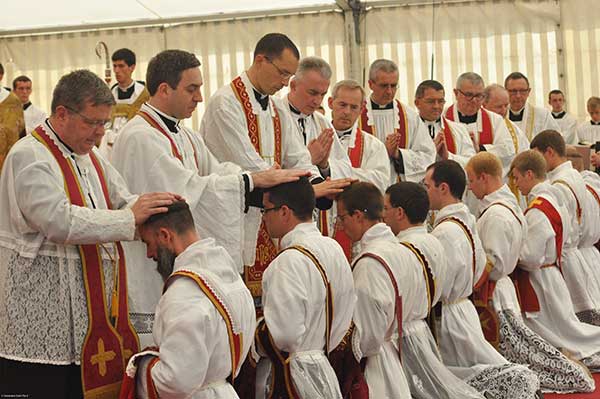 i sacerdoti impongono le mani agli ordinandi sacerdoti
